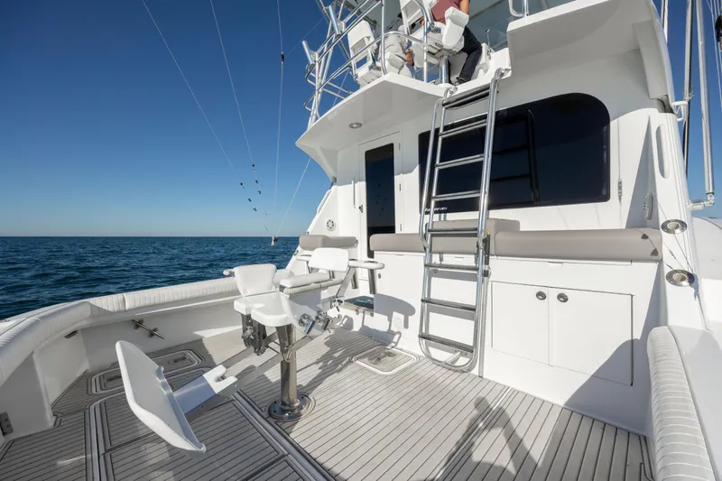 Slide: The Image of 2000 Hatteras 50 Convertible yacht deck with fishing chairs and ladder, on open sea. - 21