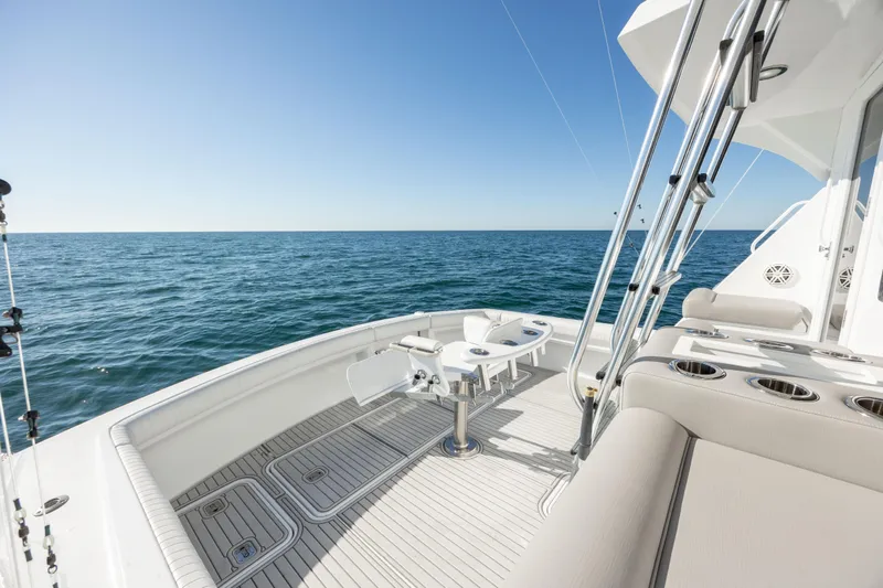 Slide: The Image of Hatteras 50 Convertible 2000 yacht deck with ocean view, featuring fishing equipment. - 22