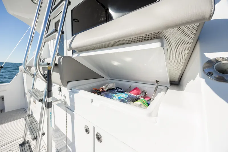 Slide: The Image of Storage compartment on 2000 Hatteras 50 Convertible yacht, open with various items inside. - 26