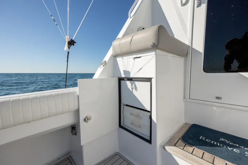 Slide: The Image of Hatteras 50 Convertible 2000 yacht deck with storage, ocean view, and fishing rod holder. - 28
