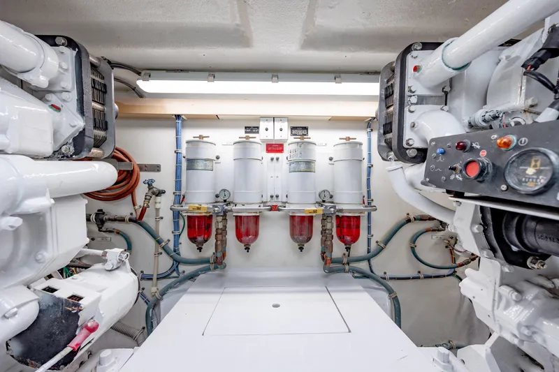 Slide: The Image of Engine room of 2000 Hatteras 50 Convertible yacht, featuring fuel filters and control panels. - 38
