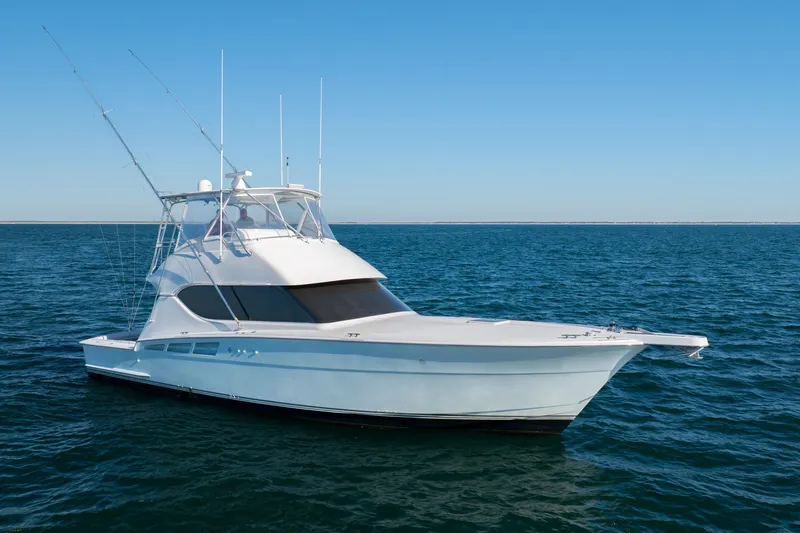 Slide: The Image of 2000 Hatteras 50 Convertible yacht on open sea under clear blue sky. - 4
