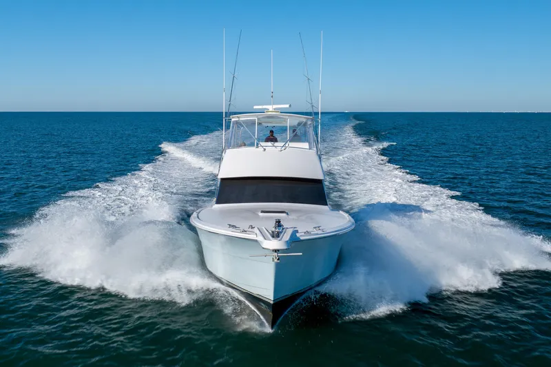Slide: The Image of Hatteras 50 Convertible yacht cruising on open sea, 2000 model, creating dynamic water spray. - 78