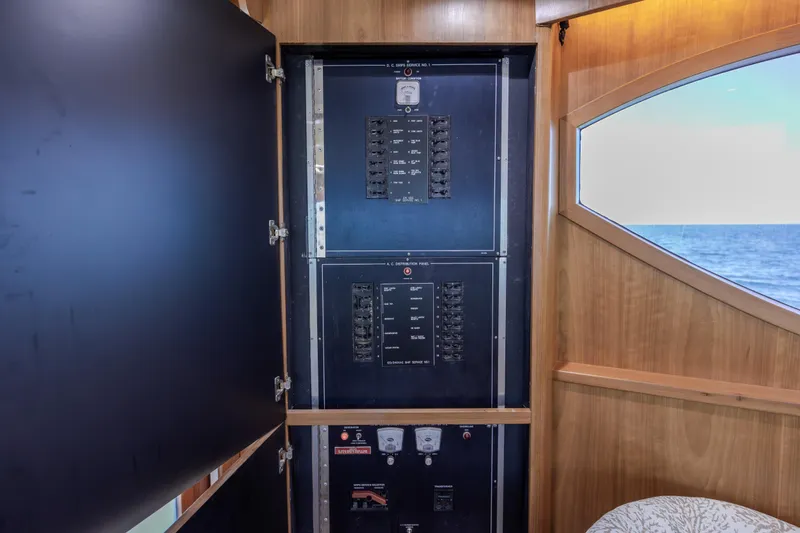 Slide: The Image of Electrical panel inside 2000 Hatteras 50 Convertible yacht, with ocean view through window. - 56