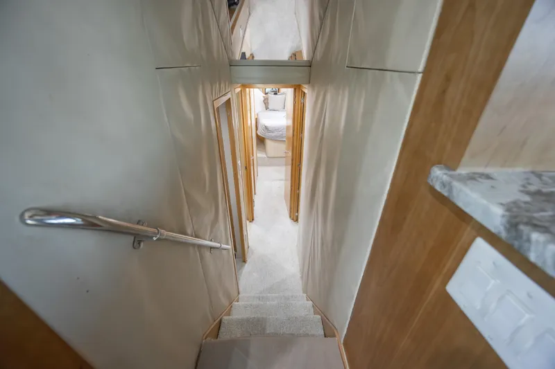 Slide: The Image of Interior view of 2000 Hatteras 50 Convertible yacht, featuring narrow hallway and bedroom. - 57