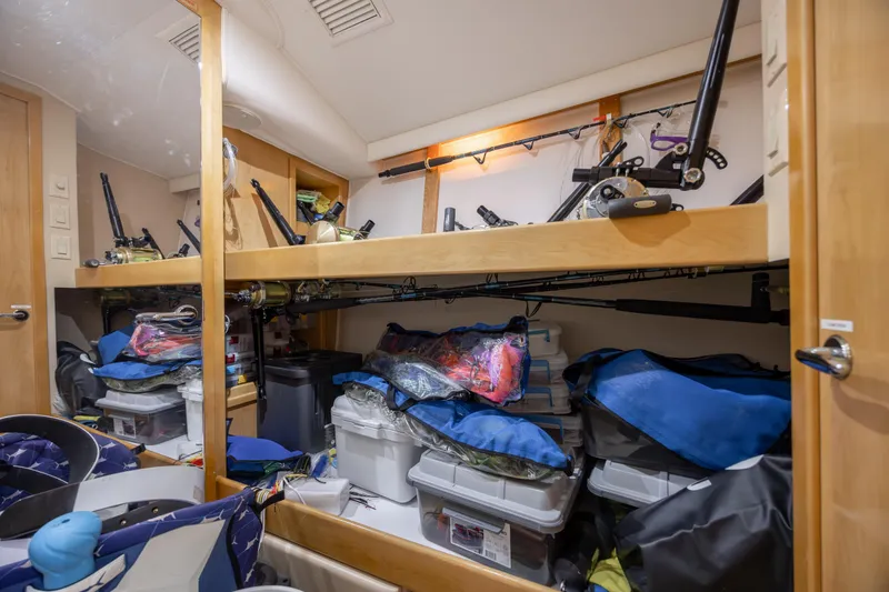 Slide: The Image of Storage area in a 2000 Hatteras 50 Convertible, featuring fishing gear and equipment. - 59
