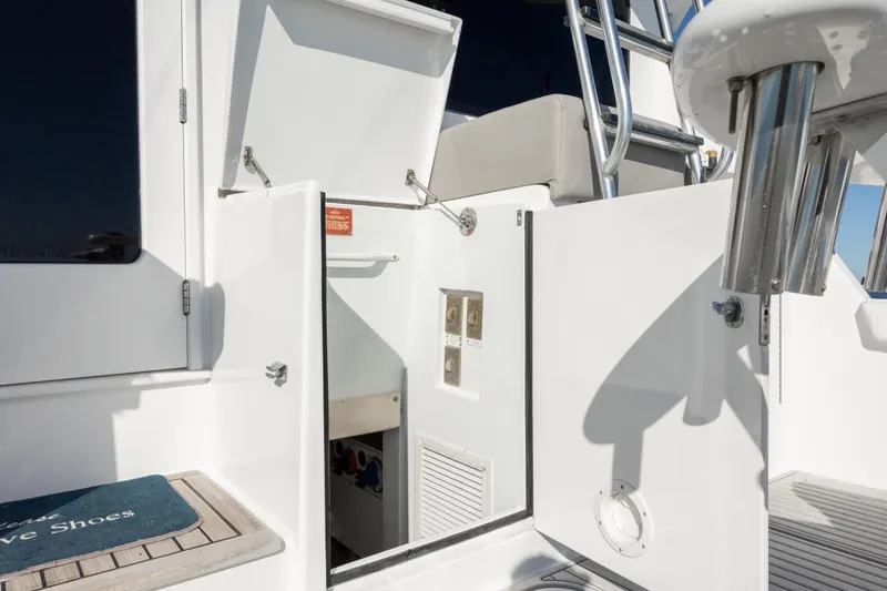 Slide: The Image of 2000 Hatteras 50 Convertible yacht, open storage compartment, stainless steel ladder, and deck details. - 33