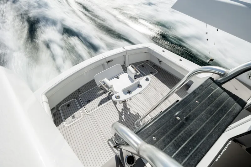 Slide: The Image of Hatteras 50 Convertible 2000 yacht deck with fishing chair, cruising on water. - 89
