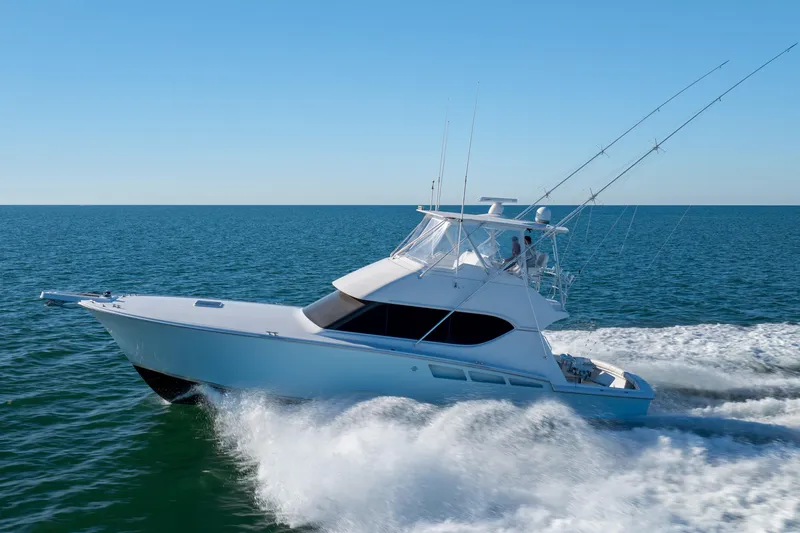 Slide: The Image of 2000 Hatteras 50 Convertible yacht cruising on open sea under clear blue sky. - 80