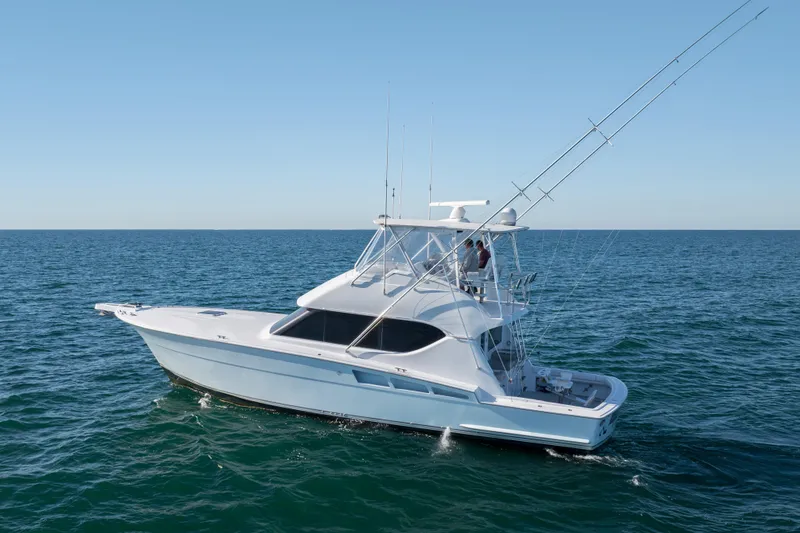 Slide: The Image of 2000 Hatteras 50 Convertible yacht cruising on open sea under clear sky. - 7