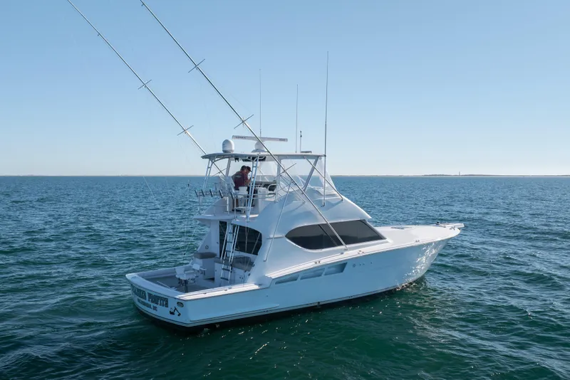 Slide: The Image of 2000 Hatteras 50 Convertible yacht cruising on open water under clear skies. - 5