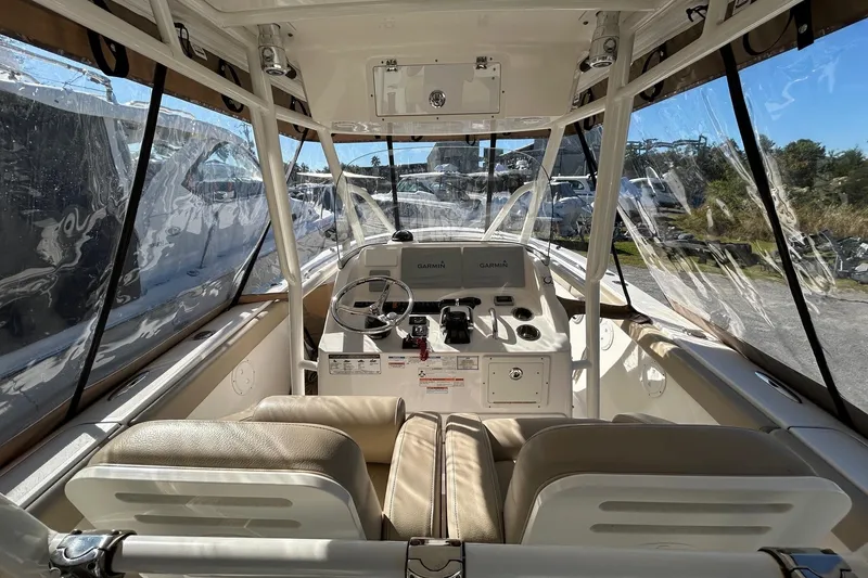 Slide: The Image of 2015 Pursuit C 280 Center Console boat interior with steering wheel and navigation equipment. - 11