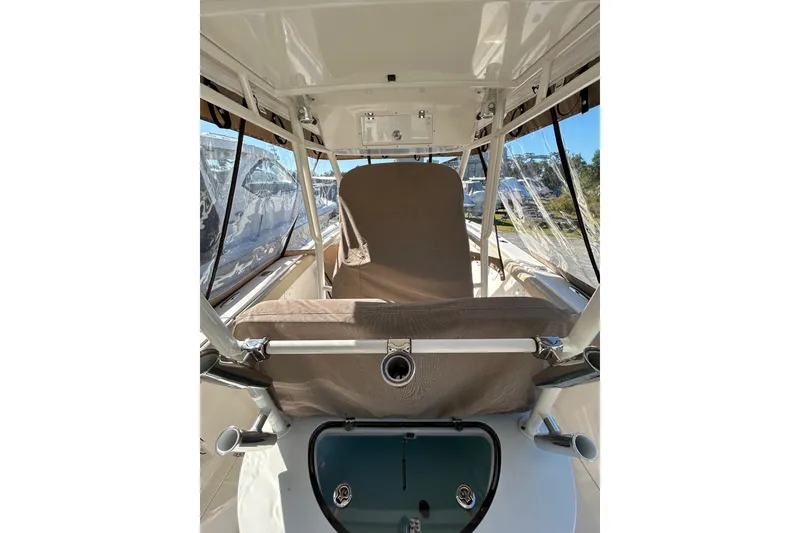Slide: The Image of 2015 Pursuit C 280 Center Console boat interior with covered seating and rod holders. - 13