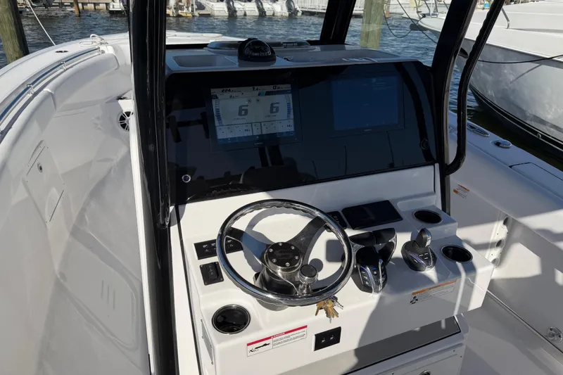 Slide: The Image of 2024 Sportsman Open 282TE Center Console boat dashboard with steering wheel and controls. - 12