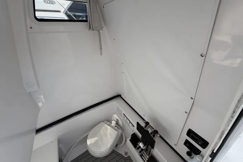 Slide: The Image of 2024 Sportsman Open 282TE Center Console interior with marine toilet and storage. - 16