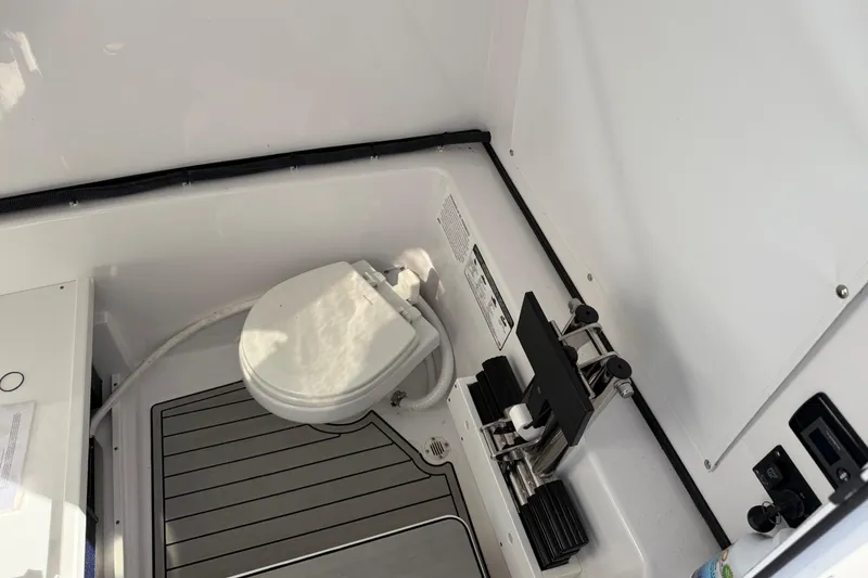 Slide: The Image of 2024 Sportsman Open 282TE Center Console boat interior with toilet and equipment. - 17