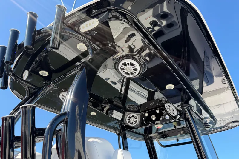 Slide: The Image of 2024 Sportsman Open 282TE Center Console, sleek black T-top with speakers and rod holders. - 20