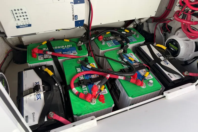 Slide: The Image of 2024 Sportsman Open 282TE Center Console battery compartment with multiple batteries and wiring. - 28