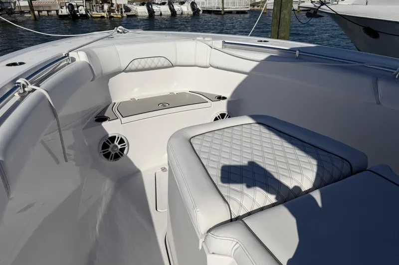 Slide: The Image of 2024 Sportsman Open 282TE Center Console boat interior with cushioned seating and speakers. - 34