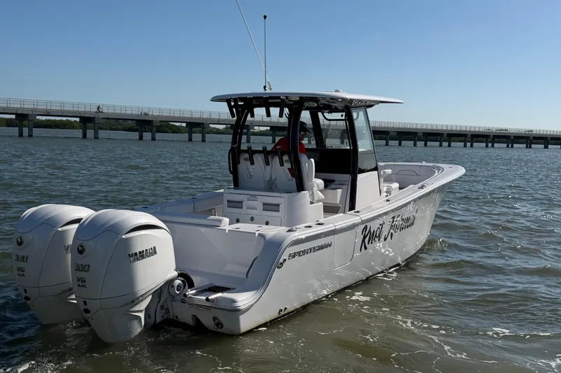 Slide: The Image of 2024 Sportsman Open 282TE Center Console boat with twin Yamaha engines on water. - 5