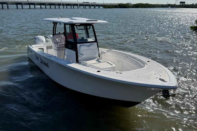 Slide: The Image of 2024 Sportsman Open 282TE Center Console boat on water, sunny day. - 7