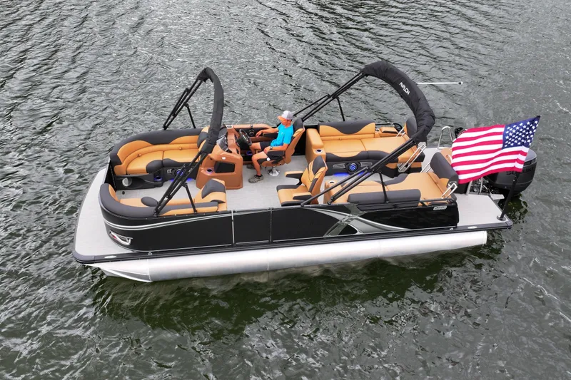 The Image of 2026 Avalon LSZ Quad Lounger Shift pontoon boat on water with American flag. - 0