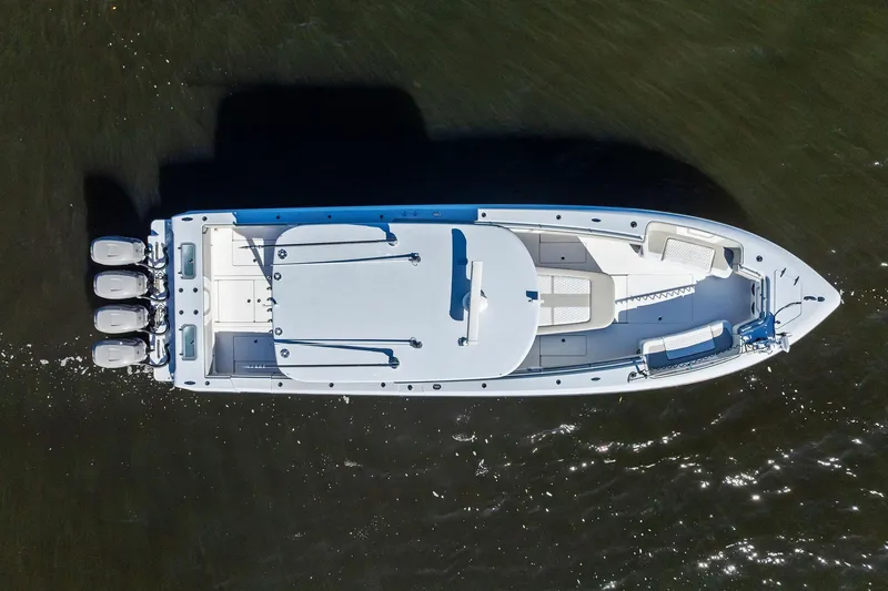 Slide: The Image of Aerial view of 2022 Contender 44 CB boat with triple outboard engines on water. - 10