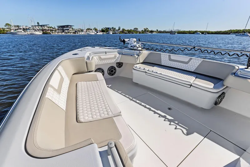 Slide: The Image of 2022 Contender 44 CB boat interior with cushioned seating, on a sunny day by the water. - 11