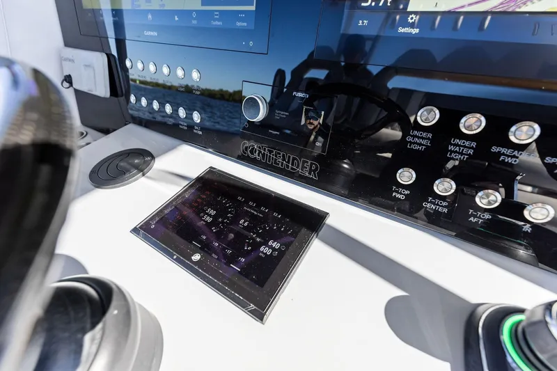 Slide: The Image of Control panel of 2022 Contender 44 CB boat with Garmin display and various controls. - 23