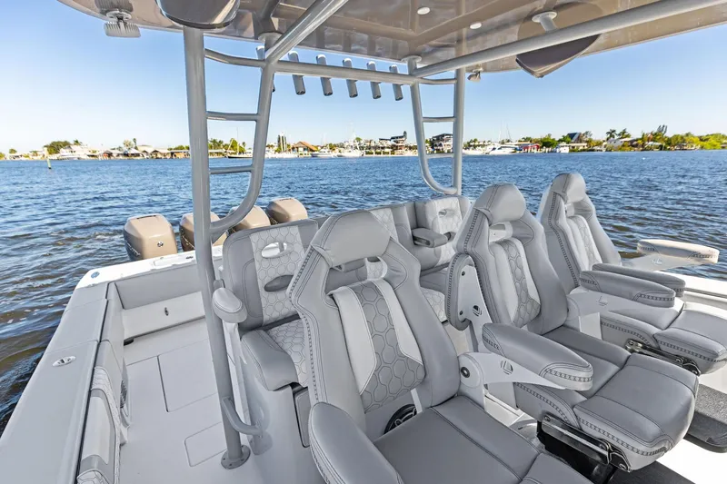 Slide: The Image of 2022 Contender 44 CB boat interior with luxurious seating on a calm waterfront. - 26