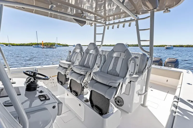Slide: The Image of 2022 Contender 44 CB boat interior with luxury seating and steering wheel, on calm water. - 28