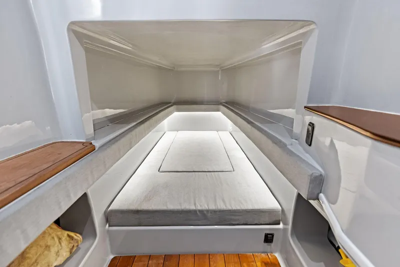 Slide: The Image of 2022 Contender 44 CB cabin interior with cushioned bed and wooden accents. - 33