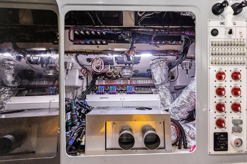 Slide: The Image of Engine room of 2022 Contender 44 CB boat, showcasing wiring and control panels. - 35