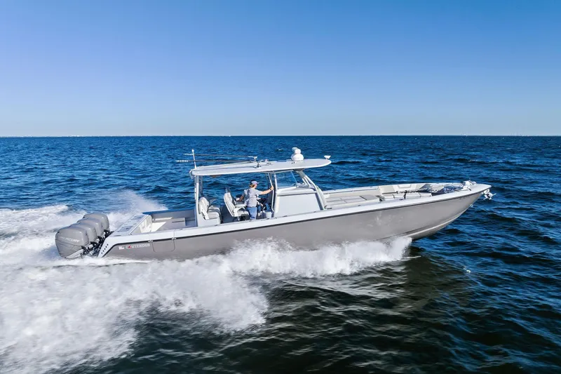 Slide: The Image of 2022 Contender 44 CB boat cruising on open water with multiple outboard engines. - 53