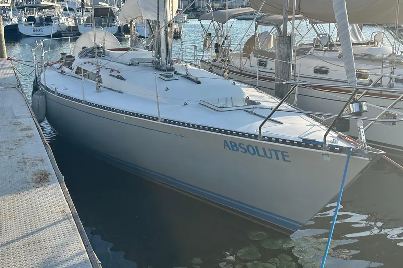 Slide: The Image of 1984 C&C 41 sailboat named "Absolute" docked at a marina. - 1