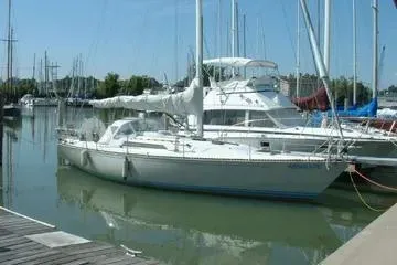 Slide: The Image of 1984 C&C 41 sailboat docked in a marina, surrounded by other boats. - 2