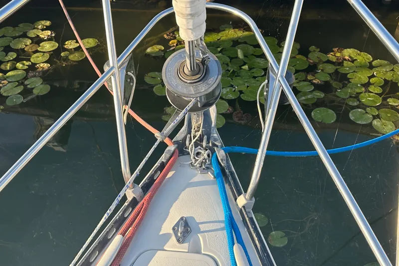 Slide: The Image of Bow of a 1984 C&C 41 sailboat with ropes and lily pads in water. - 27