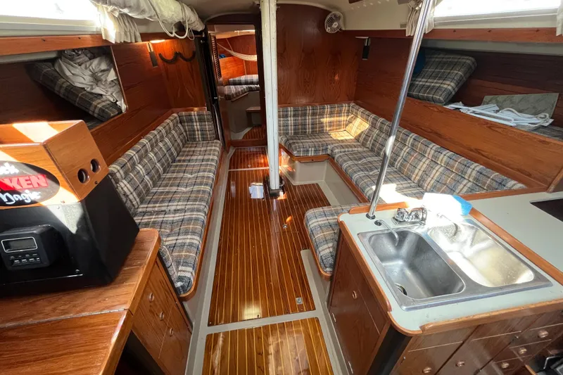 Slide: The Image of Interior of a 1984 C&C 41 sailboat with plaid seating and wooden finishes. - 34