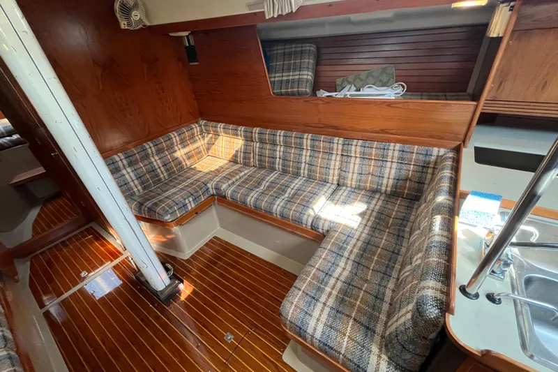 Slide: The Image of Interior of a 1984 C&C 41 sailboat with plaid seating and wooden finishes. - 36