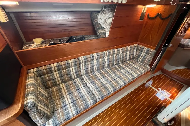 Slide: The Image of 1984 C&C 41 yacht interior with plaid seating and wooden paneling. - 37