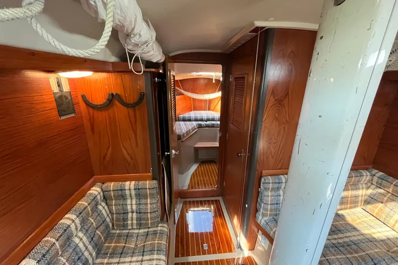 Slide: The Image of Interior of 1984 C&C 41 sailboat with wood paneling and plaid seating. - 38