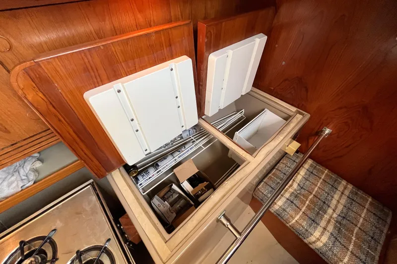Slide: The Image of Interior of 1984 C&C 41 sailboat showing open storage compartments and wooden cabinetry. - 45