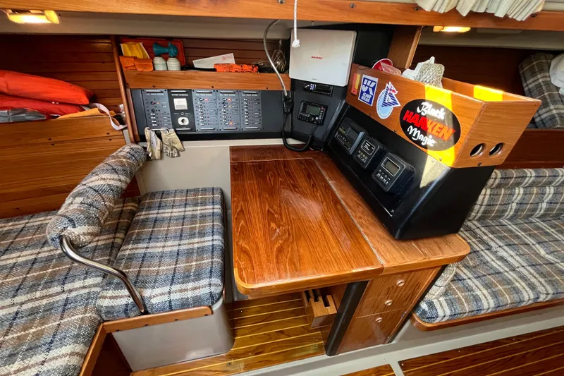 Slide: The Image of 1984 C&C 41 yacht interior with navigation station and plaid seating. - 46