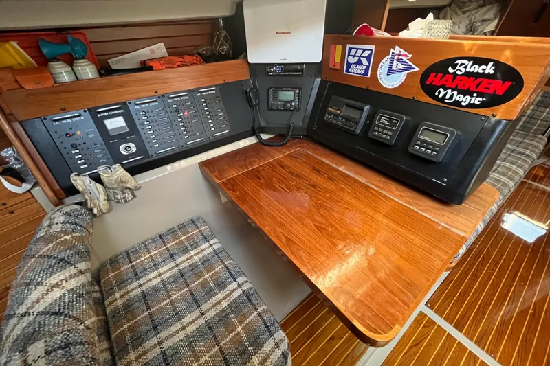 Slide: The Image of Navigation station of a 1984 C&C 41 sailboat with control panels and wooden table. - 47