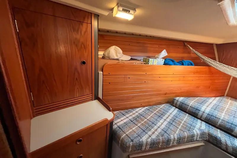 Slide: The Image of Cozy cabin interior of 1984 C&C 41 sailboat with wooden paneling and plaid cushions. - 50