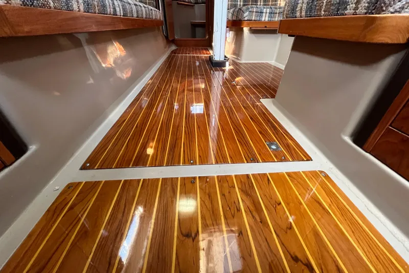 Slide: The Image of Polished wooden floor inside 1984 C&C 41 sailboat cabin, featuring cozy seating. - 55