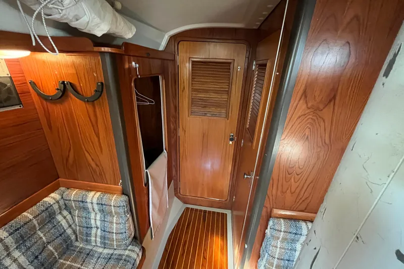 Slide: The Image of Interior of 1984 C&C 41 sailboat with wood paneling and plaid seating. - 56