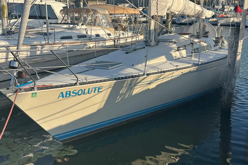 Slide: The Image of 1984 C&C 41 sailboat named "Absolute" docked at a marina. - 60