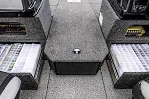 Slide: The Image of 2026 Lund 1875 Impact XS SS boat interior with open storage compartments and steering console. - 10