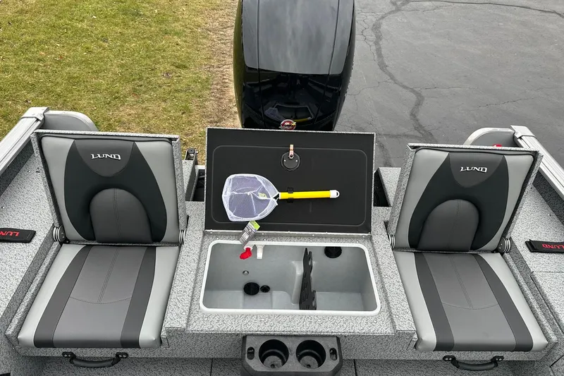 Slide: The Image of 2026 Lund 1875 Impact XS SS boat interior with seating and storage compartments. - 13